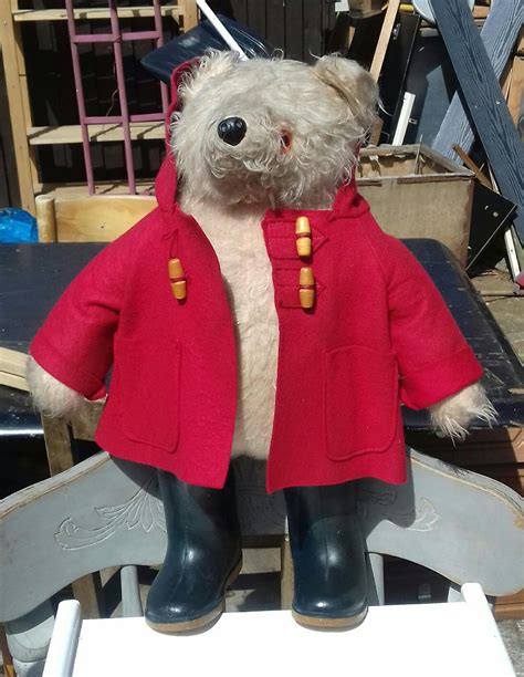 Dressed in sweater, scarf, denim pants. . Original paddington bear with dunlop wellies